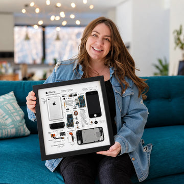 Woman holding an iPhone 1st Generation Teardown Frame in a modern living room